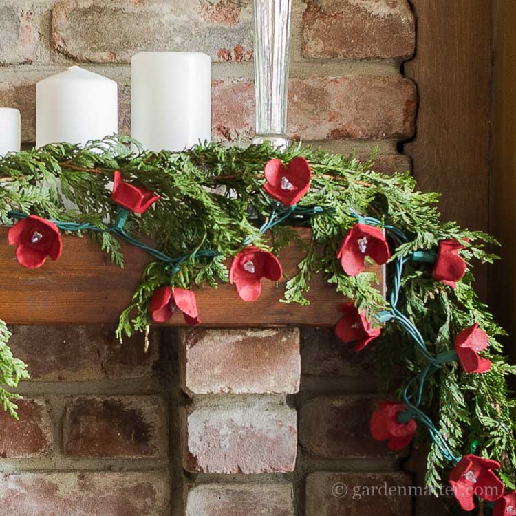Learn how to make this easy egg carton flower garland for you holiday decor. This garland works great with greens, and is pretty enough to stand on its own.